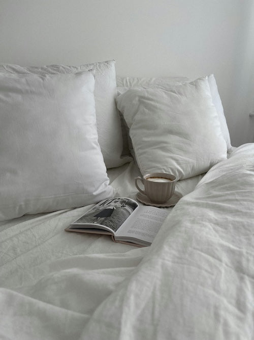 a bed with a cup of tea and a book